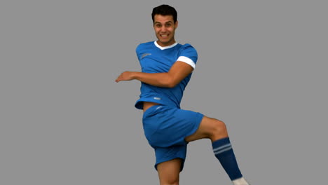 jugador de fútbol pateando un fútbol en la pantalla gris
