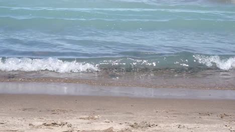 smalls waves crashing to beach shoreline