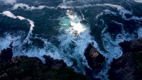 4K-Drone-footage-of-waves-crashing-around-Lands-End-in-Cornwall,-England