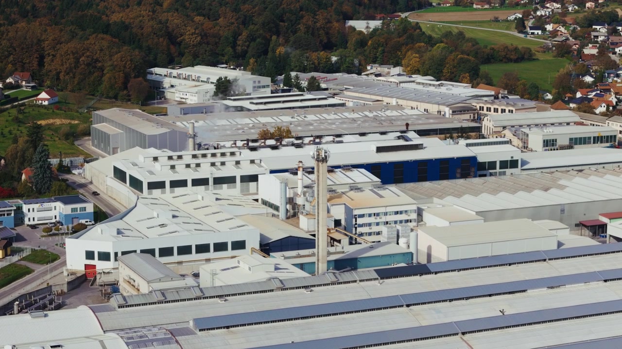 Esta vista aérea muestra una gran fábrica de aluminio rodeada de varios edificios industriales y