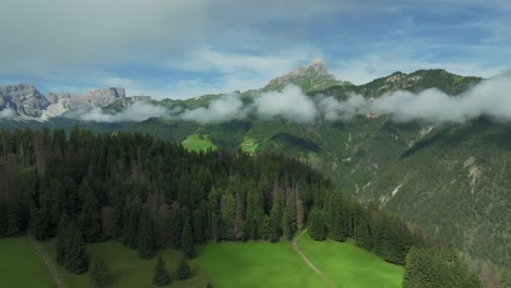 drone glides back, framing sass de putia in cloud-kissed dolomites