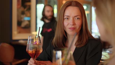 a poised and elegant woman smiles joyfully while holding a colorful drink in a chic restaurant a poised and elegant woman smiles joyfully while holding a colorful drink in a chic restaurant atmosphere
