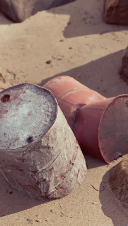 rusty barrels on a sandy beach