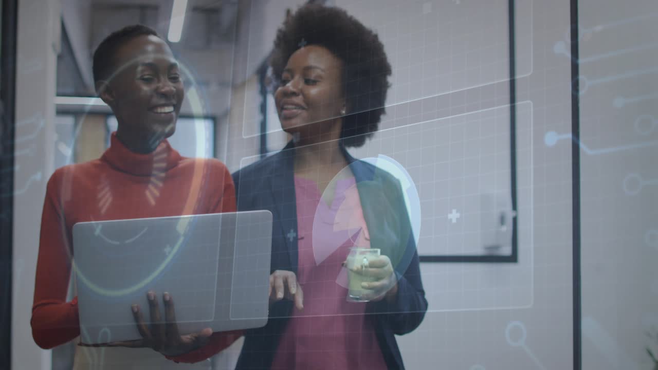 Utente di laptop tecnologico che digita per attivare un grafico mentre un collega con caffè discute i dati