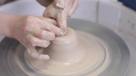 the master potter teaches the child to work with clay on a potter's wheel.