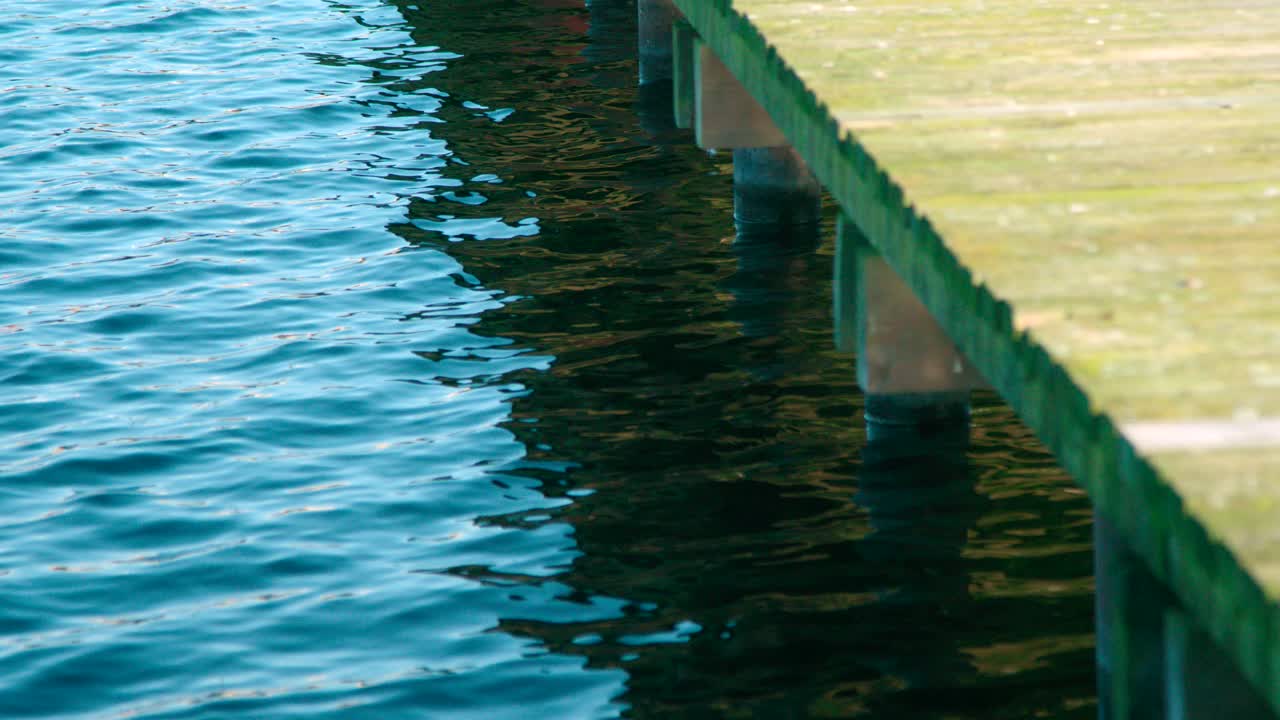 부두 근처의 파도 물에 잔물결과 태양 섬광