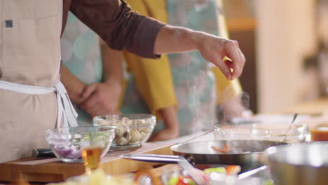 chef adding spices while frying food during cooking master class