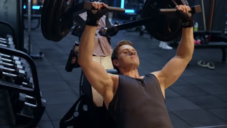 sporty caucasian man training in incline chest press machine at modern gym