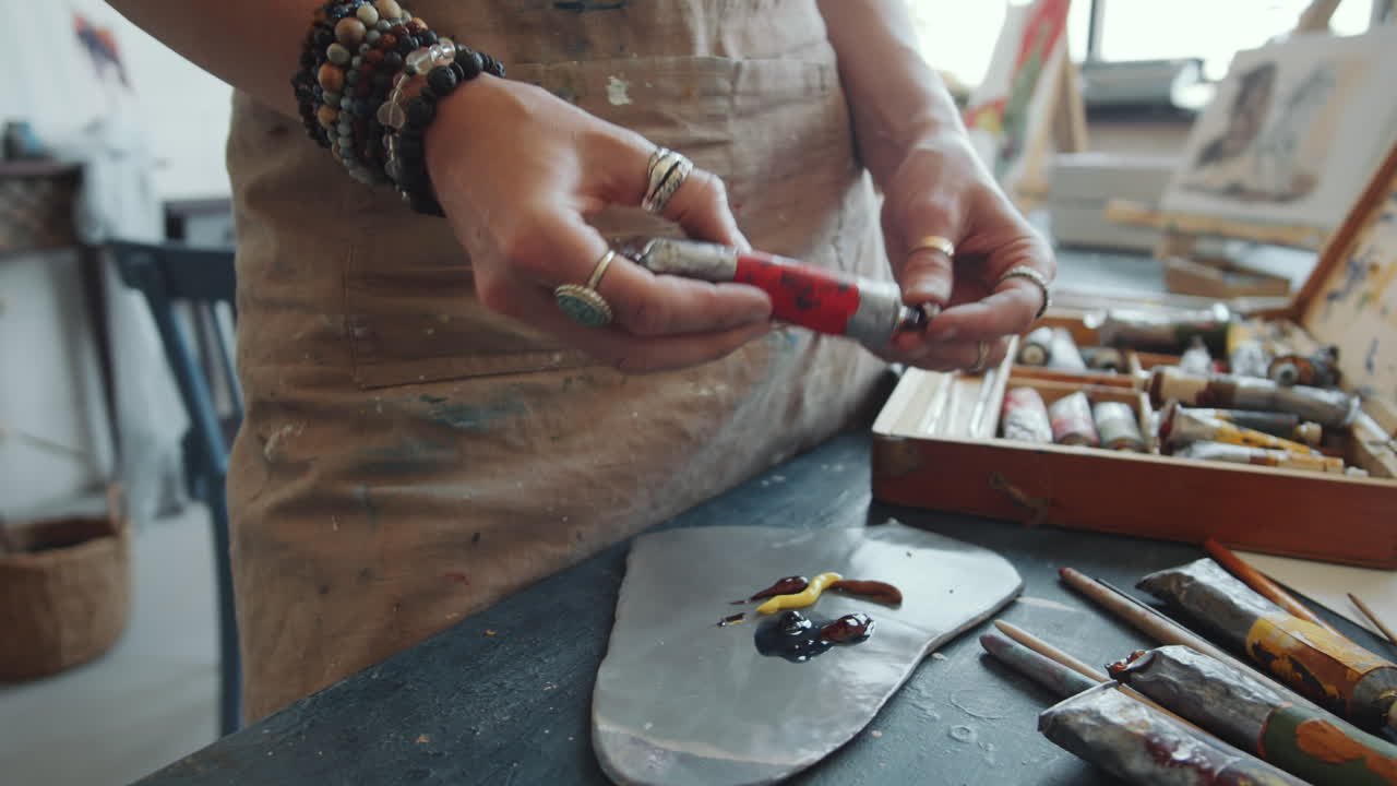 Woman Artist Mixing Paint in Studio