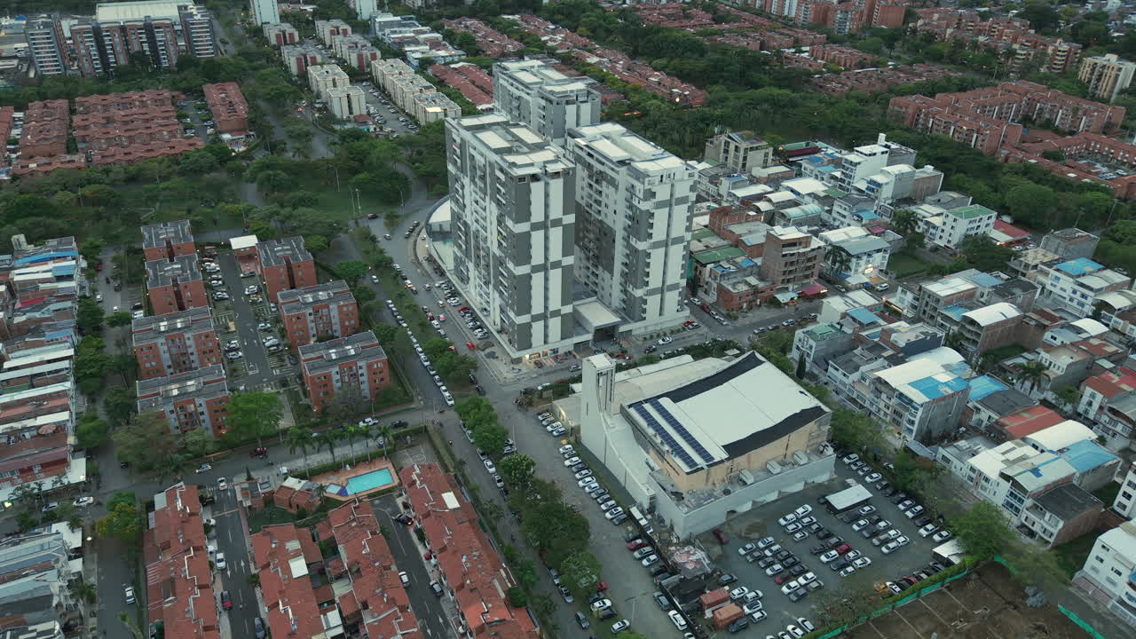 Aerial footage capturing the bustling urban landscape of Valle del Cauca. High-rise buildings, intricate streets, and vibrant architecture under a soft, diffused daylight