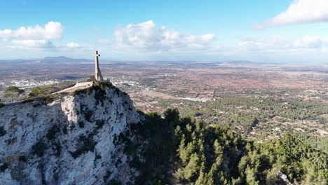 fotografía aérea de aproximación de la cruz de piedra de sant salvador en la cima de la colina y el hermoso paisaje panorámico de la isla de mallorca, españa