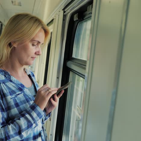 a young traveler uses a tablet in the train car 1