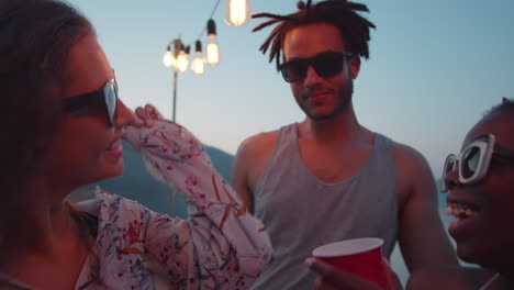 man dancing with girls at lake party in evening