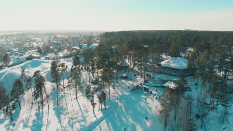 ski-resort-and-wide-snowy-track-on-hill-under-sky-upper-view