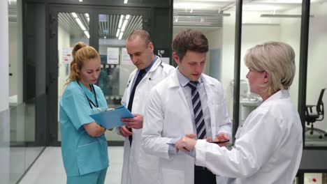 equipo de médicos interactuando entre sí en el pasillo