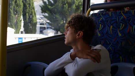 male commuter looking through window while travelling in bus 4k