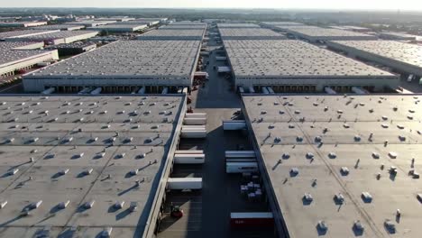 aerial view of a large distribution center highlighting its expansive roofs and truck loading areas, illustrating the efficiency and scale of modern logistics operations