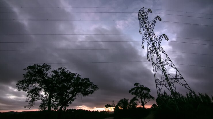 Dramatic clouds over silhoeutted electrical lines and pylon, timelapse