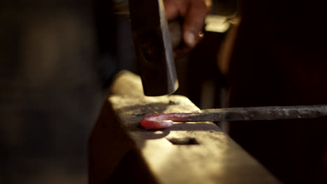 blacksmith forging hot metal on anvil