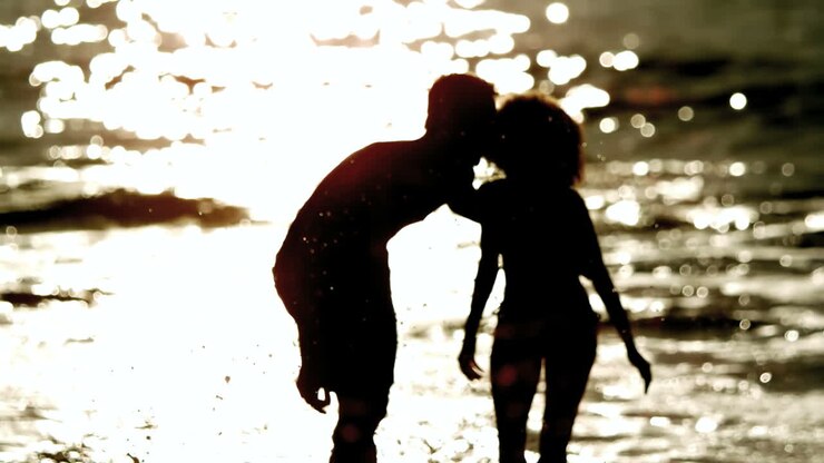 Amis s'éclaboussant dans la mer le soir