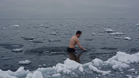 man swimming in cold icy water