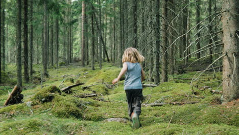 free-spirited young kid runs over moss-covered woodland floor between trees