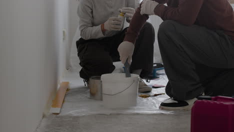 couple mixing paint for home renovation