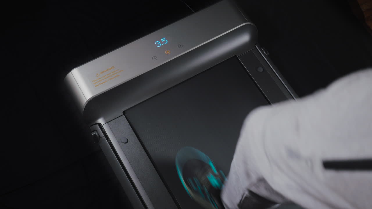 primer plano estático de los pies de un hombre caminando sobre una cinta rodante-1