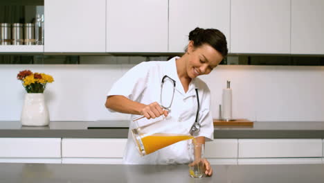 Home-nurse-pouring-orange-juice-in-kitchen