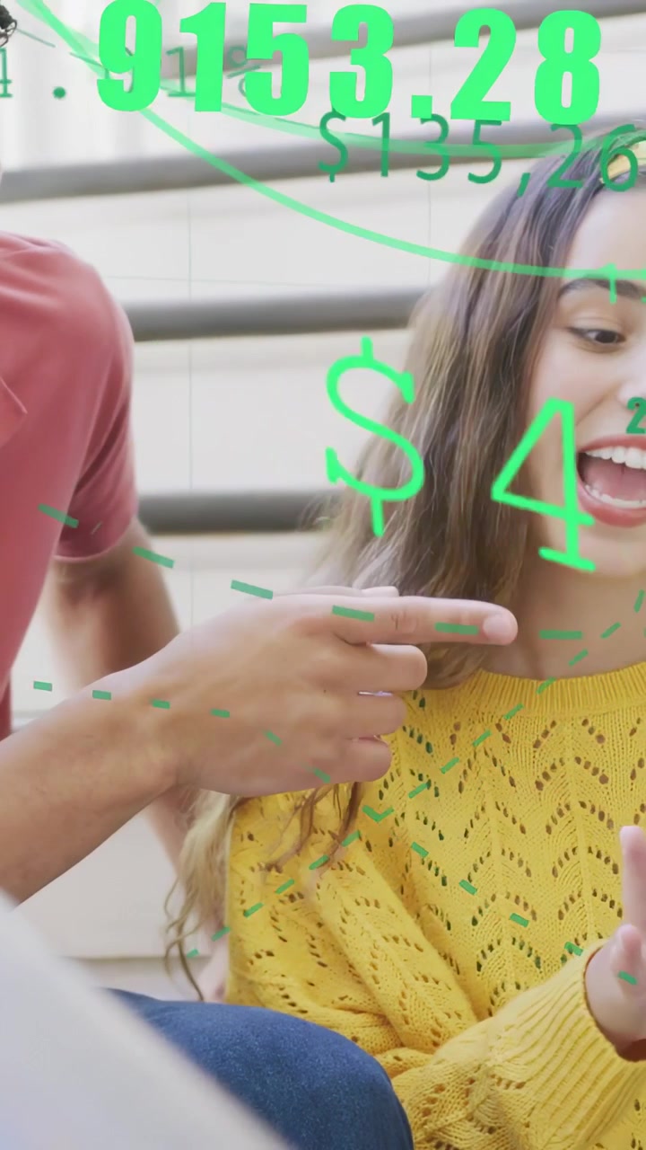 Vertical video: Man leaning in pointing at phone on steps woman tapping reviewing green tech charts