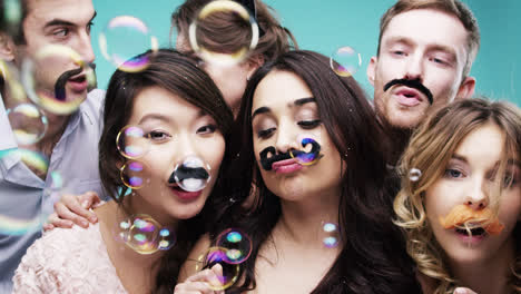 grupo multi-racial de personas que llevan bigote falso para la cabina de fotos de la fiesta de movimiento lento de movember