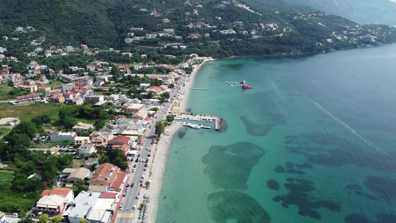 Dolly in aerial, up-close view of exotic Ipsos Beach with transparent turquoise waters in Corfu, Greece