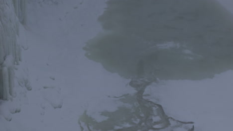 frozen waterfall stream on winter season, tilt down