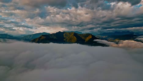 Glide-above-the-clouds-in-this-stunning-drone-footage,-as-majestic-mountain-peaks-emerge-in-the-background,-providing-a-breathtaking-backdrop-to-the-verdant-Yungas-cloud-forest-below