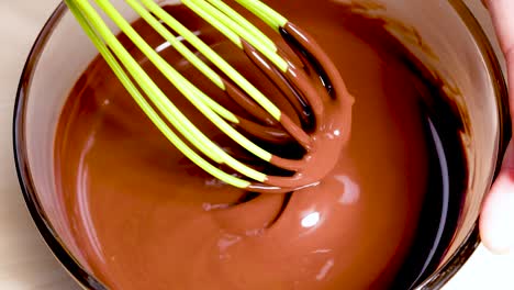 smooth chocolate being whisked in a glass bowl