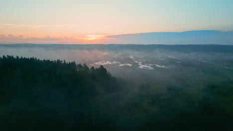 Mist-rising-above-forest-landscape-in-national-park-of-Latvia,-aerial-view