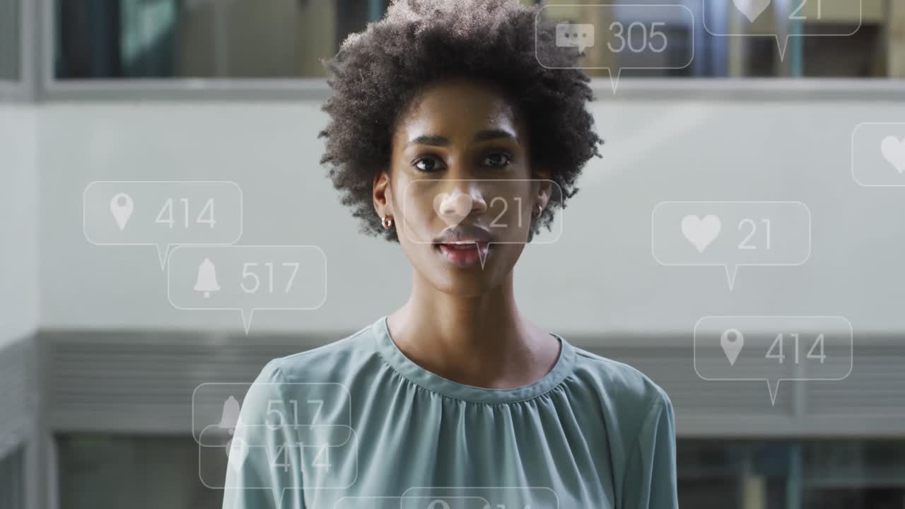 Animation of social media icons floating over african american businesswoman smiling at office