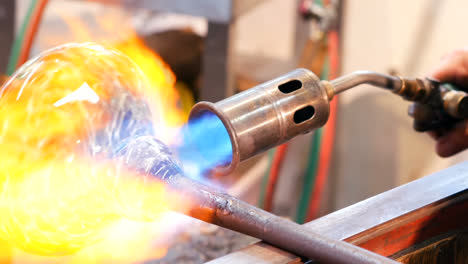 glassblower shaping a molten glass