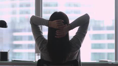 rear view of successful businesswoman relax sit in office chair