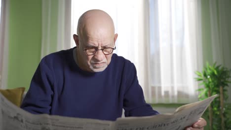 depressed and lonely old man reading newspaper to spend time at home.