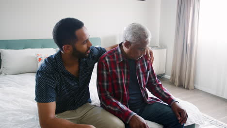 Hijo-Adulto-Consolando-A-Padre-Mayor-Que-Sufre-Depresión-En-Casa