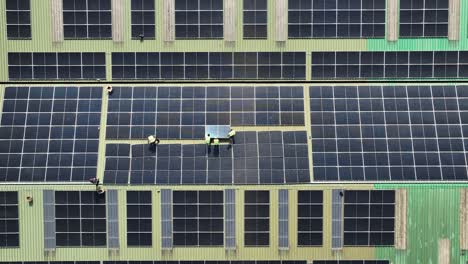 factory workers installing photovoltaic panels on roof