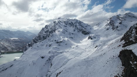 Fly-Over-Majestic-Mountain-Peaks-in-the-Alps-from-a-Drone-in-Winter-on-a-sunny-day,-Italy