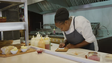 mujer de raza mixta escribiendo en la cocina