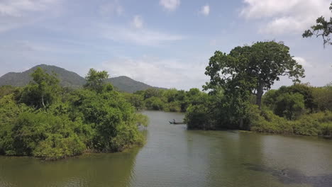 Hombres-De-Sri-Lanka-En-Bote-De-Canoa-Remar-En-El-Humedal-Del-Pantano-De-Yala,-Antena-Baja