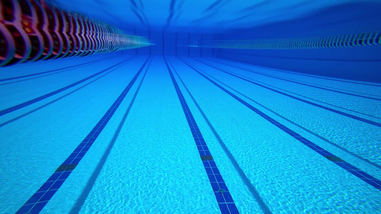 Olympisk svømmebassin under vandbaggrund.