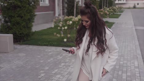 Woman Walking Outdoors on a City Street with a Phone