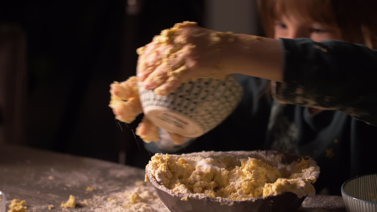 Little girl child pouring sugar into butter dough mix with messy hands