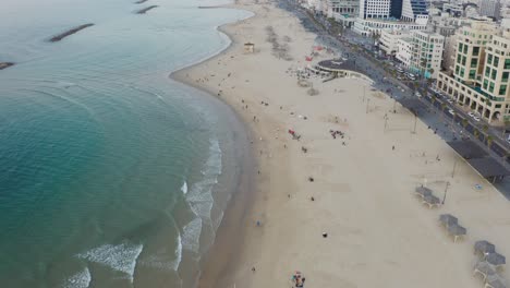 4k aerial - blue waves, boardwalk - tel aviv beach during sunset