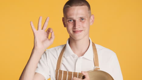 hombre feliz dando la señal de ok y sosteniendo la bandeja de oro